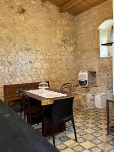 a table and chairs in a room with a stone wall at Casa Betta in Modica