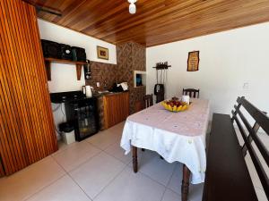 a kitchen with a table with a bowl of fruit on it at Pousada Jardim in Lauro Müller
