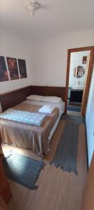 ein Schlafzimmer mit einem Bett und einem Spiegel auf dem Boden in der Unterkunft Casa Container em Monte Verde - 800m do Centro in Monte Verde