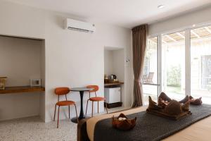 a bedroom with a bed and a table and chairs at Sea Escapes Resort in Thongsala