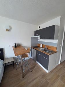 a small kitchen with a table and a sink at Joli studio Disneyland Paris 2 pers in Bussy-Saint-Georges
