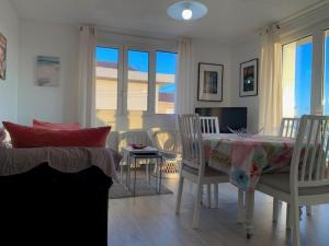 a living room with a table and chairs and a dining room at Charmant T3 à 15 min des Thermes de Balaruc, terrasse, clim, wifi et parking gratuit - 4 pers. - FR-1-503-137 in Balaruc-les-Bains