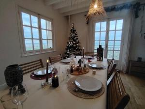 een eettafel met een kerstboom in een kamer bij Villa Bellevue - Anglo-Norman seafront house in Ouistreham