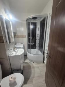 a bathroom with a shower and a toilet and a sink at Homzy Craiova in Craiova