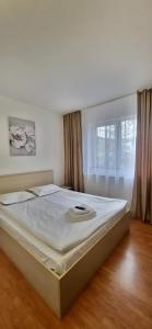 a large bed in a bedroom with a window at Homzy Craiova in Craiova