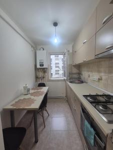 a small kitchen with a table and a stove at Homzy Craiova in Craiova +9 photos