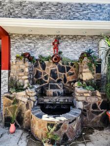 a stone fountain in front of a brick building at Xe 'Gakasiiwaan in San Juan La Laguna