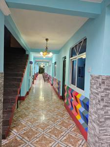 a corridor of a building with colorful tile floors at Xe 'Gakasiiwaan in San Juan La Laguna