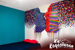 a room with a wall covered in colorful sprinkles at Xe 'Gakasiiwaan in San Juan La Laguna