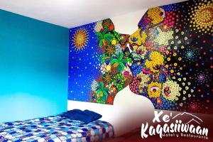 a bedroom with a painting on the wall at Xe 'Gakasiiwaan in San Juan La Laguna