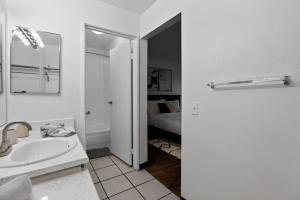 a white bathroom with a sink and a bed at Bright modern studio featuring full kitchenette in Las Vegas +12 photos
