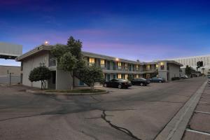 a building with cars parked in a parking lot at Bright modern studio featuring full kitchenette in Las Vegas
