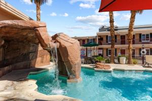 a swimming pool with a waterfall in a resort at Bright modern studio featuring full kitchenette in Las Vegas
