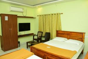 een slaapkamer met een bed en een televisie. bij Sri KASTHURI Residency in Tiruttani