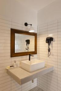 a bathroom with a sink and a mirror at Sea Escapes Resort in Thongsala