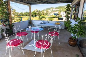 un patio con sillas rojas y una mesa en el balcón en Apartments Rux de Luxe, en Bar