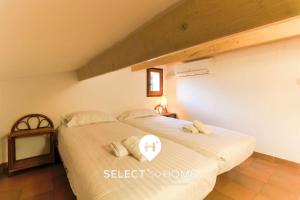 ein Schlafzimmer mit einem großen Bett mit weißen Laken und Kissen in der Unterkunft SELECT'SO HOME - Villa PANORAMA - Services hôteliers & prestations de qualité in Le Lavandou + 1 Foto