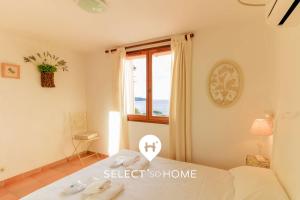 ein Schlafzimmer mit einem Bett und einem Fenster in einem Zimmer in der Unterkunft SELECT'SO HOME - Villa PANORAMA - Services hôteliers & prestations de qualité in Le Lavandou