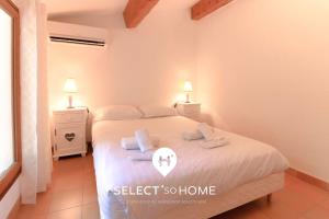 ein Schlafzimmer mit einem Bett, auf dem zwei Handtücher liegen in der Unterkunft SELECT'SO HOME - Villa PANORAMA - Services hôteliers & prestations de qualité in Le Lavandou