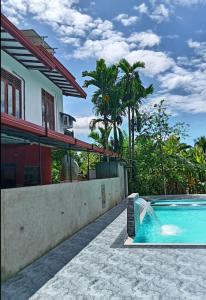 une piscine devant une maison dans l'établissement Peacock Villa Resort, à Uda Walawe
