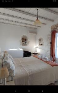 a bedroom with a white bed in a room at Villa Petradi (150 meters from the sea) in Ambelas