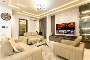 un salon avec deux canapés et une télévision dans l'établissement Crescent Cove, Luxury 3 Bedroom Home, à Kwedonu