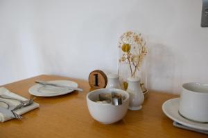 a wooden table with plates and a bowl on it at Avalon Guest House in Orkney +11 photos