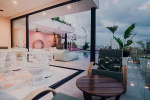 a patio with white chairs and tables and a pool at Hotel Barrio Latino in Playa del Carmen