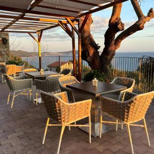 カプリオーリにあるTenuta Donna Carmelaのテーブルと椅子と木のあるパティオ