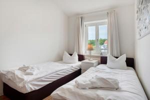 twee bedden in een kamer met een raam bij Villa Sonneck Appartement 20 in Ostseebad Sellin