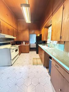 una cucina con armadi in legno e pavimento piastrellato di Lafayette Family Home-Free Parking Downtown & 3 Bedrooms a Lafayette 1 altra foto