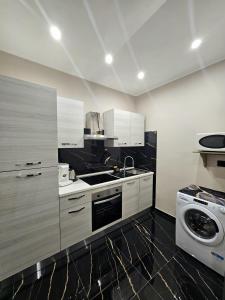 une cuisine avec un évier et une machine à laver dans l'établissement Elite holiday apartments Catanzaro, à Catanzaro 19 autres photos