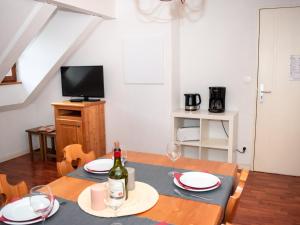 a dining room with a table with a bottle of wine at Appartement 2 Pièces pour 6 Personnes avec Piscine à Vignec près de Saint-Lary-Soulan - FR-1-504-84 in Vignec