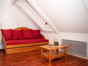 a red couch in a room with a table at Appartement 2 Pièces pour 6 Personnes avec Piscine à Vignec près de Saint-Lary-Soulan - FR-1-504-84 in Vignec