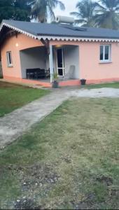 拉芒坦Résidence paisible avec vue sur les montagnes的一栋带露台和院子的粉色小房子