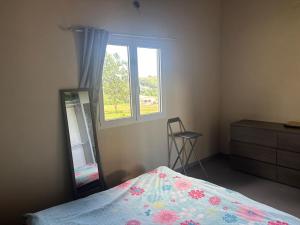 拉芒坦Résidence paisible avec vue sur les montagnes的一间带床、镜子和窗户的卧室