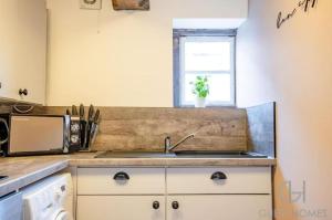 une cuisine avec un évier et un micro-ondes dans l'établissement Charming 2-Bed Apartment in Bewdley Town Centre, à Bewdley 3 autres photos