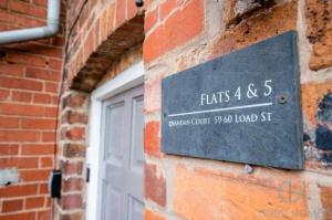 un panneau sur le côté d'un bâtiment en briques dans l'établissement Charming 2-Bed Apartment in Bewdley Town Centre, à Bewdley