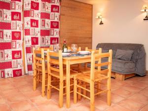 a dining room with a wooden table and chairs at Appartement cosy 2 pièces à Pra Loup avec balcon et parking - FR-1-504-231 in Uvernet-Fours