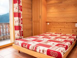 a bed in a wooden room with a window at Appartement cosy 2 pièces à Pra Loup avec balcon et parking - FR-1-504-231 in Uvernet-Fours