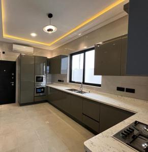 une grande cuisine avec un évier et une fenêtre dans l'établissement Crescent Cove, Luxury 3 Bedroom Home, à Kwedonu