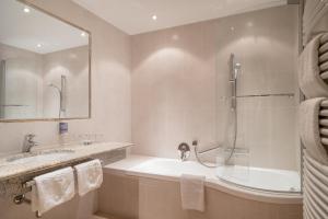 a bathroom with a tub and a sink and a shower at Alpenresidenz am Mühlbach in Obergurgl +100 photos