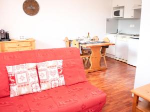 a living room with a red couch and a table at Charmant appartement 2 pièces pour 6 personnes avec balcon à Vignec, proche Saint-Lary-Soulan - FR-1-504-143 in Vignec
