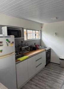 eine Küche mit weißen Schränken und einem weißen Kühlschrank in der Unterkunft Casa en Maldonado in Maldonado