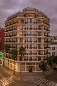 ein großes weißes Gebäude mit Palmen davor in der Unterkunft Le Square By Onomo Collection in Casablanca