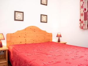 ein Schlafzimmer mit einem Bett mit einer roten Tagesdecke und 2 Lampen in der Unterkunft Appartement cosy avec balcon, piscine saisonnière, proche Saint-Lary-Soulan, jusqu'à 6 personnes - FR-1-504-148 in Vignec