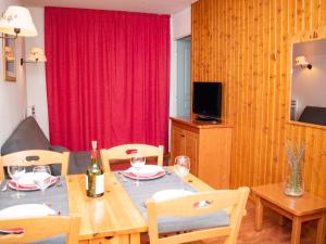 ein Esszimmer mit einem Tisch und einem roten Vorhang in der Unterkunft 2 pièces 4 pers avec balcon et coin cuisine équipé - FR-1-504-537 in Superdevoluy + 14 Fotos