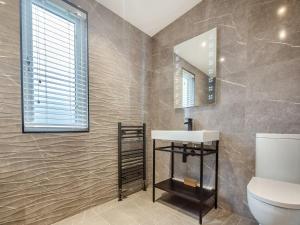 a bathroom with a sink and a mirror at Sandbanks 2 bed Lodge with hot tub - L1 in Brynteg