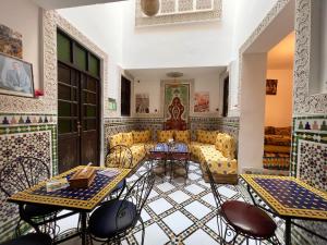 una sala de estar con sofá, mesas y sillas en Riad Dar Sbil, en Fez 84 fotos más