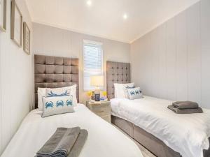 a bedroom with two beds and a window at Sandbanks 2 bed Lodge with hot tub - L1 in Brynteg